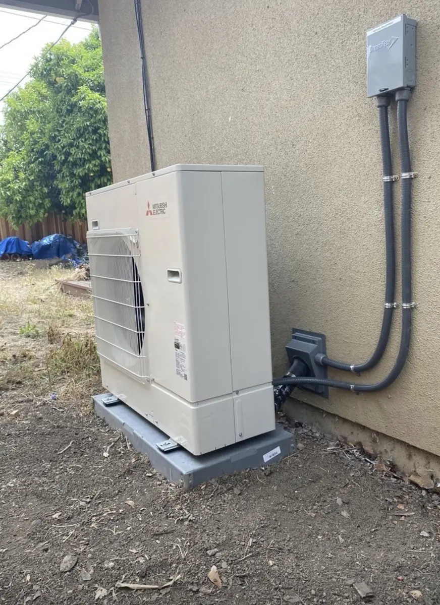 Mitsubishi Electric heat pump outdoor condenser installed on pad