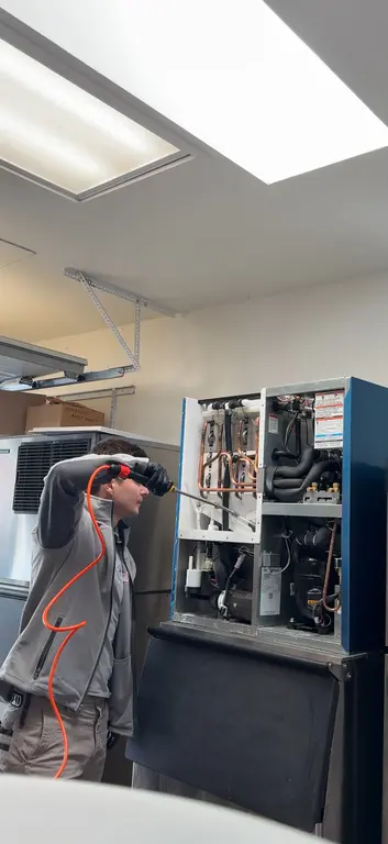 North Breeze technician using leak detector on Hoshizaki ice machine internals