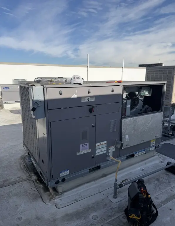 Large packaged RTU opened for maintenance with R-410A label visible