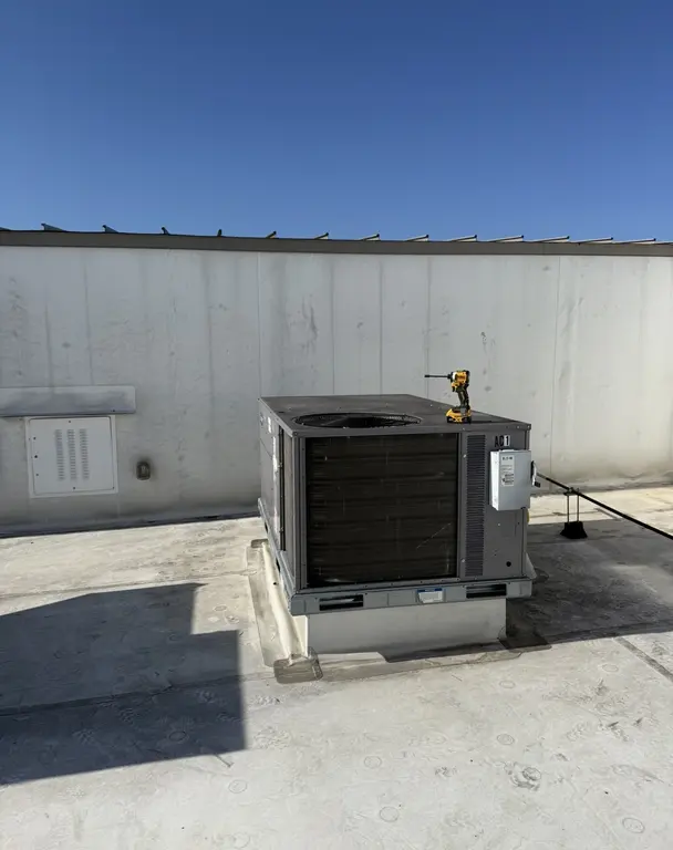 Packaged RTU on commercial rooftop with condenser coil visible