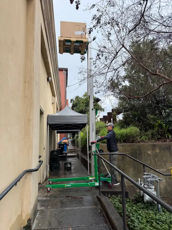 Walk-in cooler condensing unit being lifted to rooftop