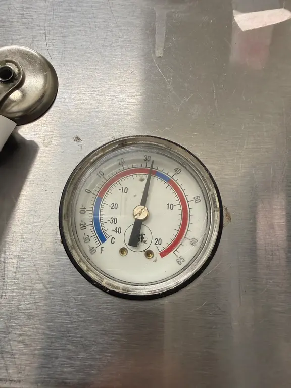 Walk-in cooler thermometer showing 35 degrees Fahrenheit after repair
