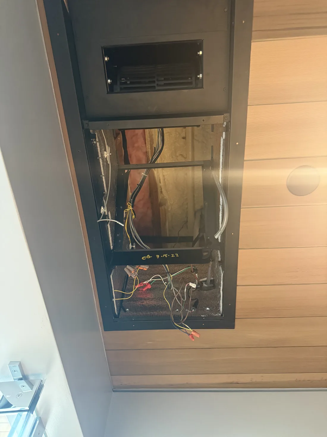 WhisperKOOL ceiling-mount evaporator cabinet open showing blower coil drain pan and electrical compartment