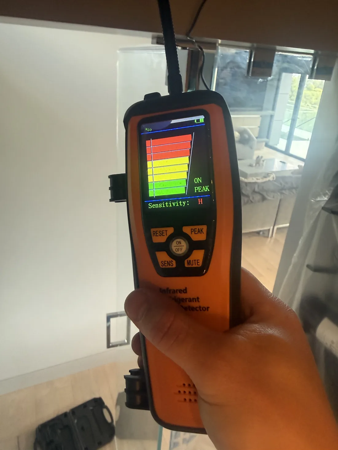 Infrared refrigerant leak detector showing peak reading at WhisperKOOL evaporator