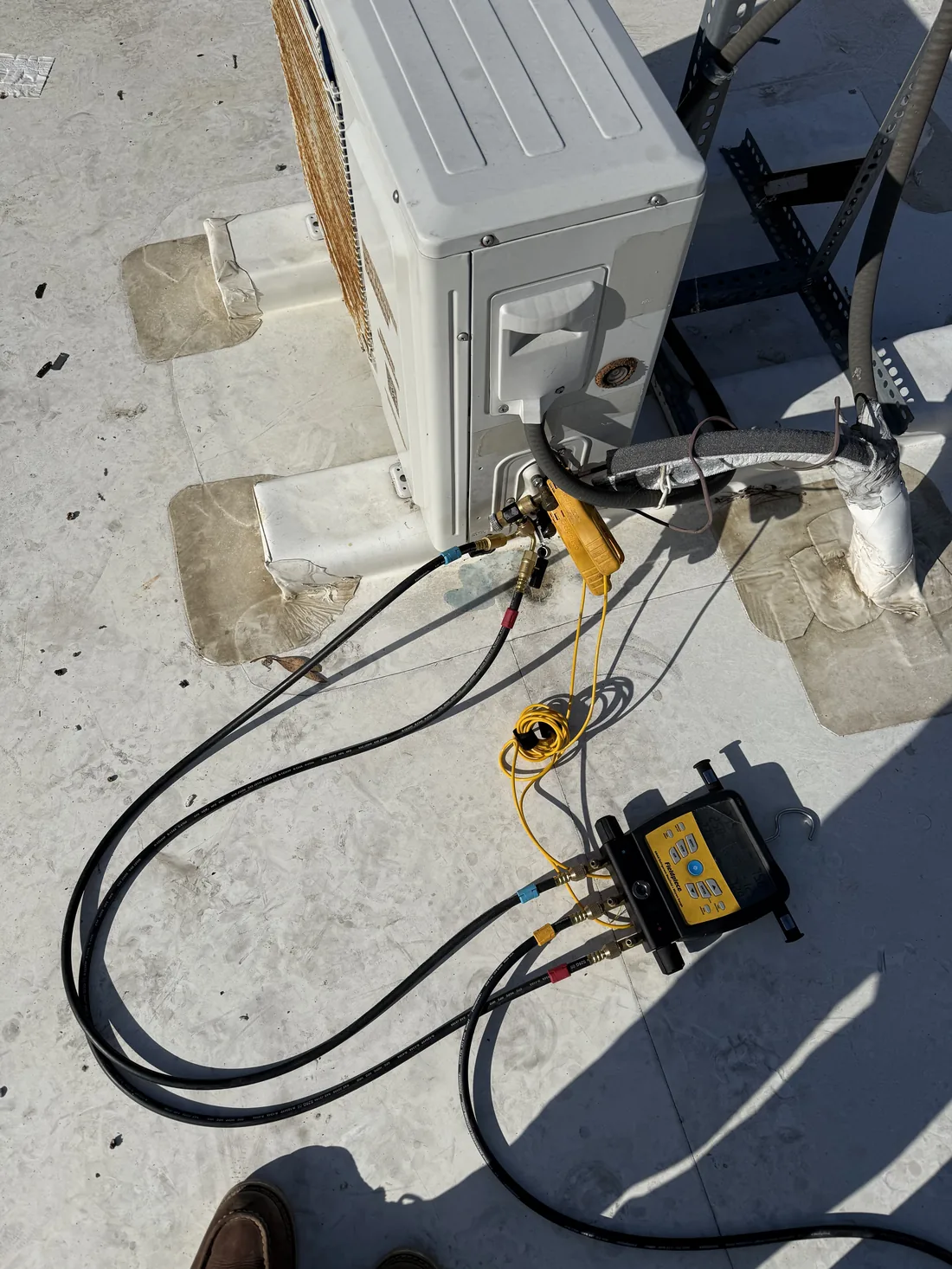 Manifold gauges and temperature probe checking superheat and subcooling on WhisperKOOL after recharge