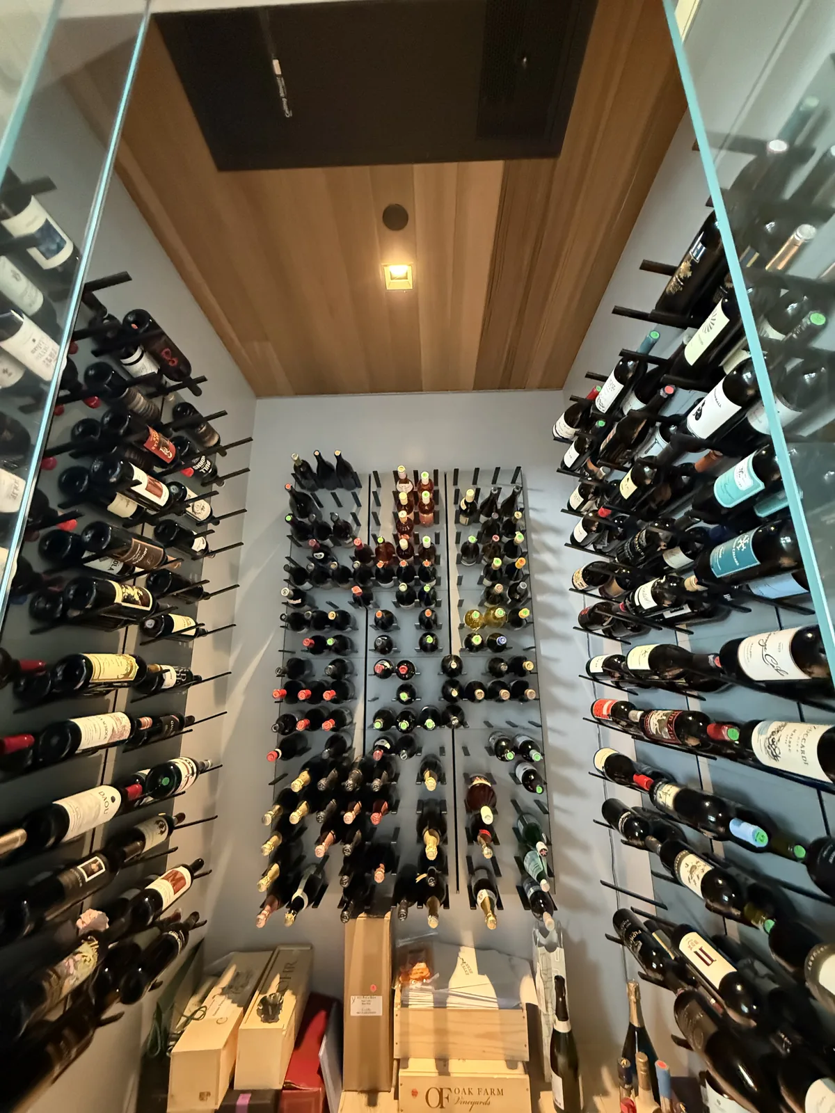 WhisperKOOL ceiling-mount wine cellar cooling unit installed in cedar ceiling with bottle racks