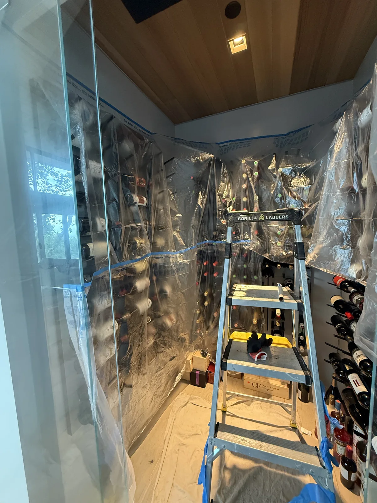 Wine cellar bottles covered with protective plastic sheeting before WhisperKOOL repair