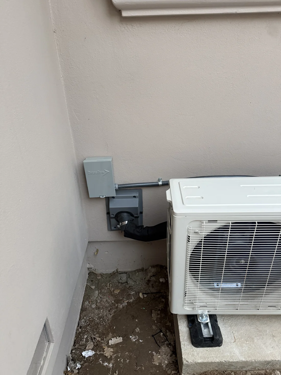 New DiversiTech electrical disconnect switch properly installed for wine cellar cooling outdoor unit with clean conduit routing